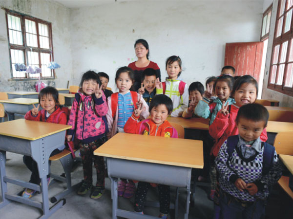 公司為一山村小學(xué)捐贈(zèng)一批課桌椅，孩子們高興地和老師一起合影